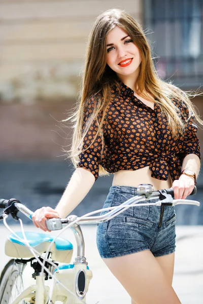 Дівчина з тримає старовинний велосипед — стокове фото