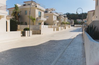 Kaldırım ağaçlar ve kırmızı kiremit ile beyaz evler sokak