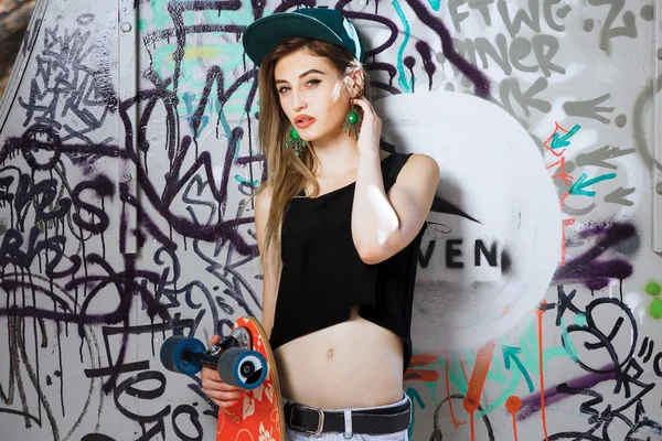 Mujer joven posando con tabla de skate —  Fotos de Stock