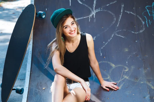 Mujer joven posando con tabla de skate — Foto de Stock
