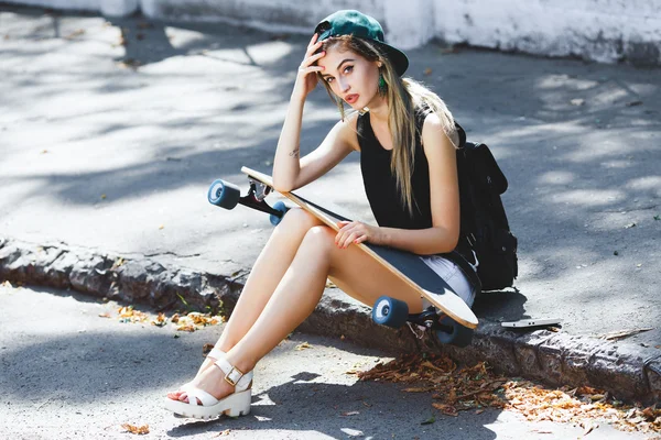 Cheerful girl sitting on the pavement — Zdjęcie stockowe