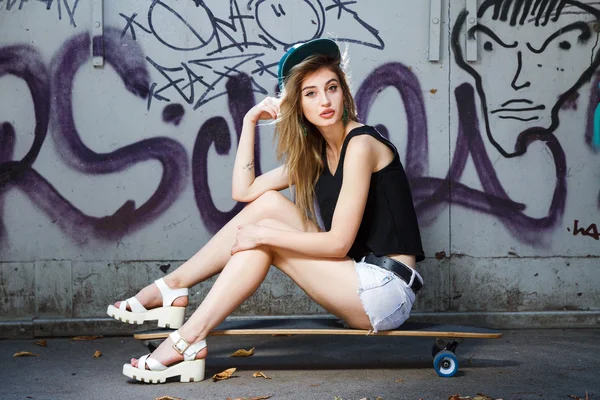 Jeune femme posant sur skateboard — Photo