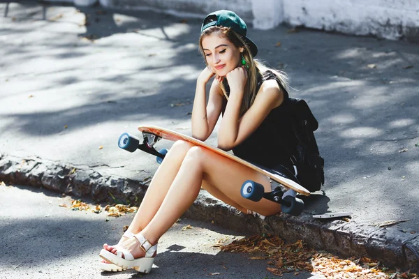Fröhliches Mädchen sitzt auf dem Bürgersteig — Stockfoto
