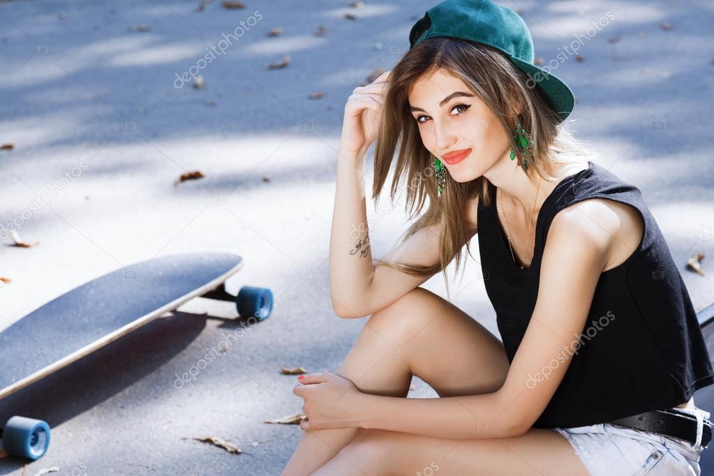 Young woman posing with skate board