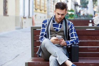 man sitting on the bench on the street