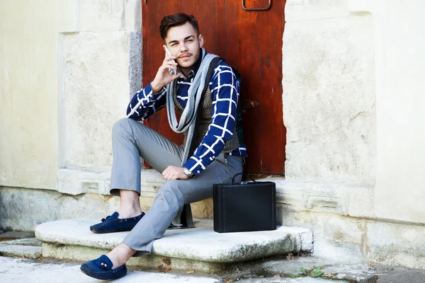 Man sitting near wooden doors — Stockfoto