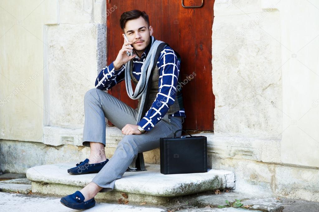 man sitting near wooden doors