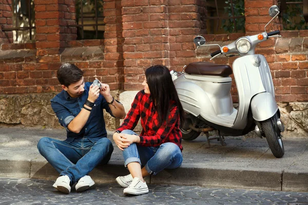 Beautiful couple sitting on the pavement — Stockfoto