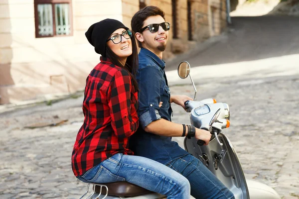 Couple riding on a vintage scooter