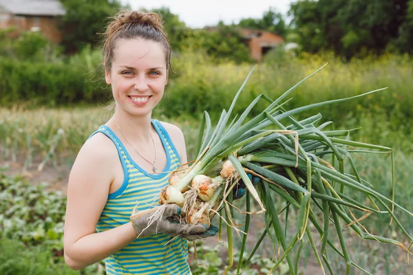Woman with bunches of onion — Stockfoto