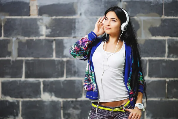 Дівчина в яскравому вбранні насолоджується музикою — стокове фото