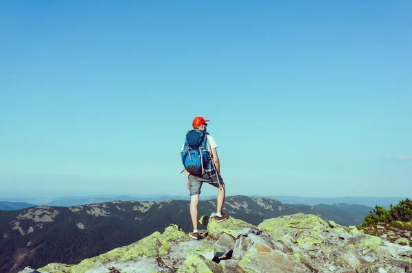 Człowiek stojący na szczycie skały — Zdjęcie stockowe