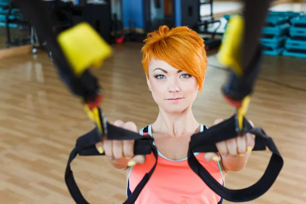 Giovane donna con TRX in palestra — Foto Stock