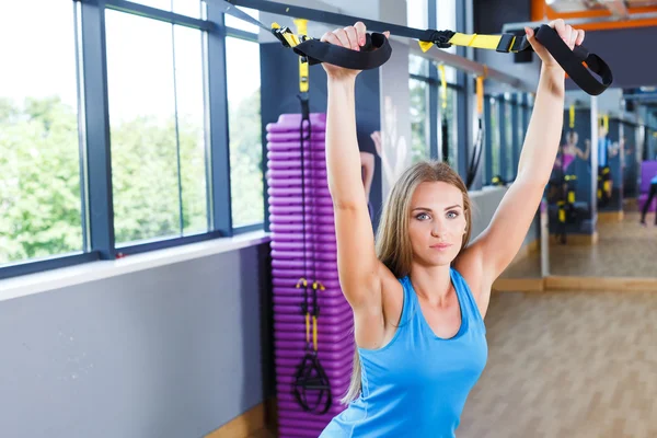 Kvinde med TRX laver øvelser - Stock-foto