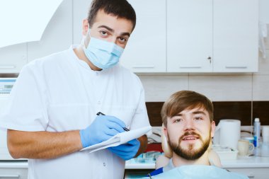 diş hekimi diş ofiste hasta ile not almak. 