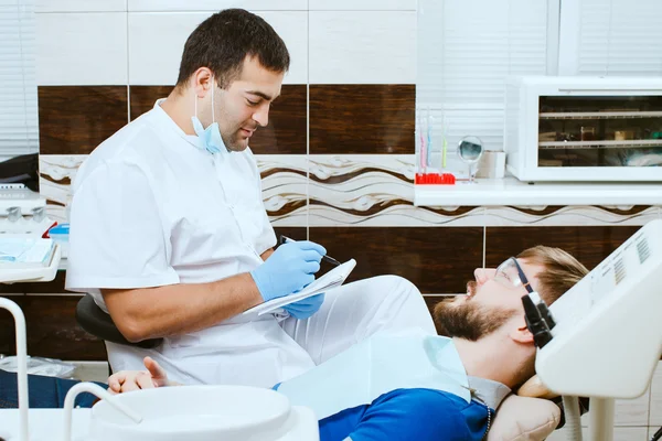 Tandläkaren tar anteckningar. — Stockfoto