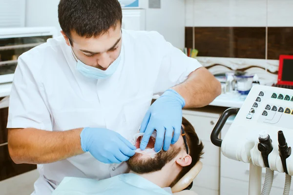 Dentista insertando optradam en el paciente — Foto de Stock