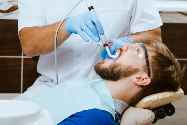 Dentista e paciente masculino — Fotografia de Stock