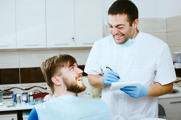 Dentista riendo con paciente feliz — Foto de Stock