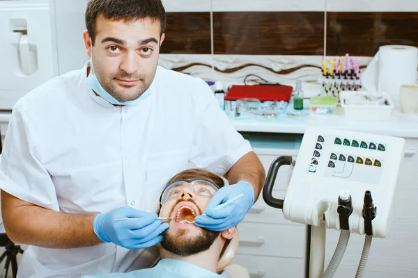 Dentista que trata los dientes del paciente . — Foto de Stock