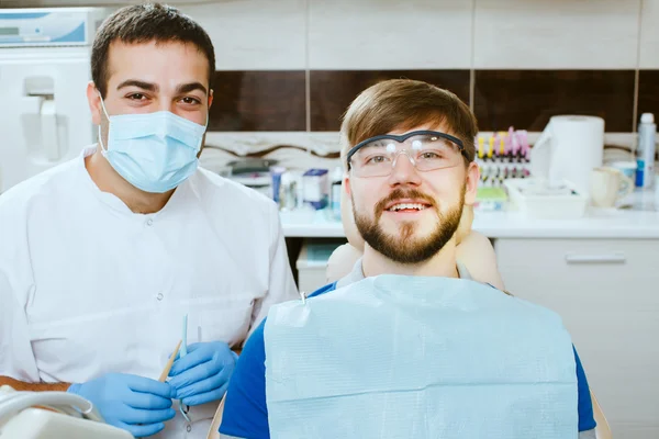 Dentista y paciente feliz en el consultorio dental . — Foto de Stock
