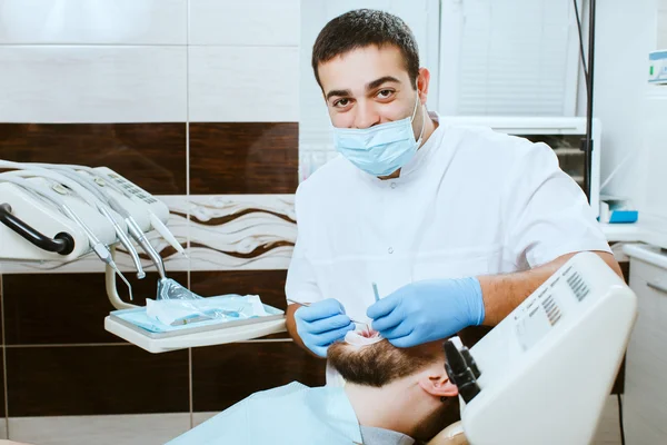 Dentista examinando dientes de hombre . — Foto de Stock