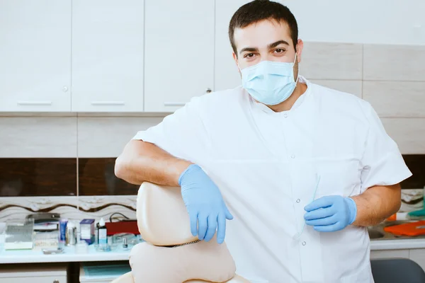 Dentista apoyado en silla de dentista — Foto de Stock