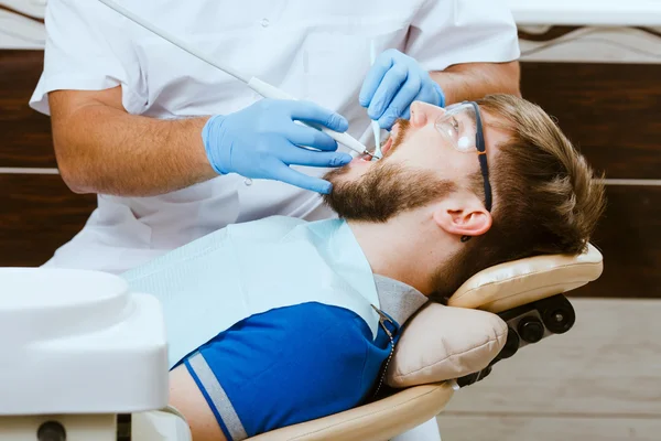 Dentista e paciente masculino — Fotografia de Stock