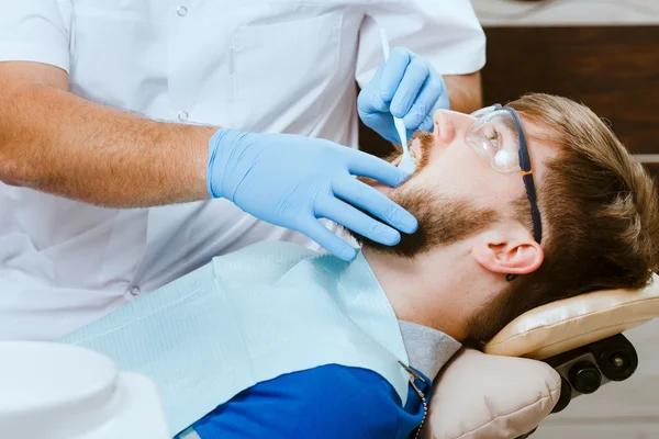 Dentista e paciente masculino — Fotografia de Stock