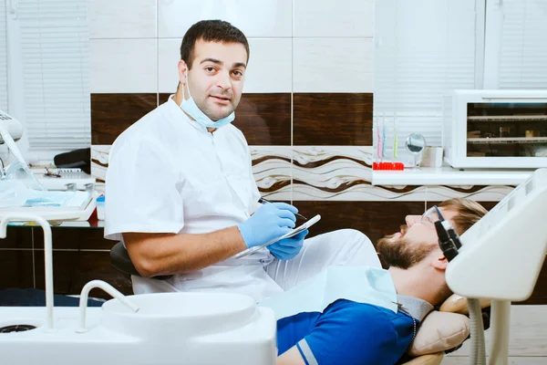 Le dentiste prend des notes. Avec le patient . — Photo