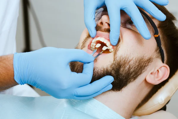 Dentista e paciente masculino — Fotografia de Stock