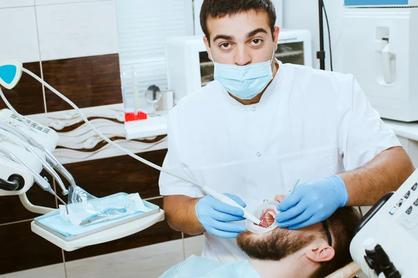 Tandarts behandelt tanden van patiënt — Stockfoto