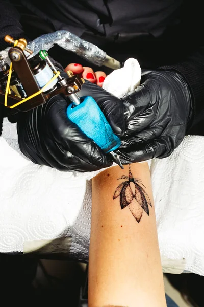 Tattoo artist works on the client's hand — Stock Photo, Image
