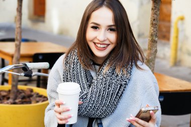girl posing with coffee and smart phone