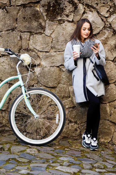 Chica sosteniendo taza de café en la calle — Foto de Stock