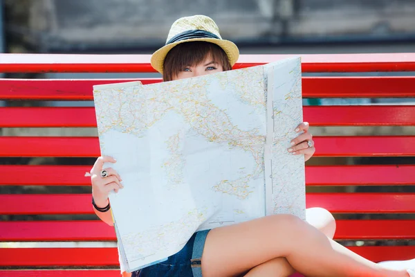 Mujer turística escondida en el mapa — Foto de Stock