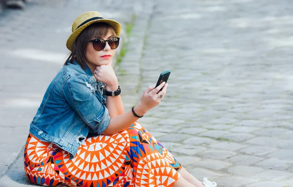 Woman sitting on the curb — Stockfoto