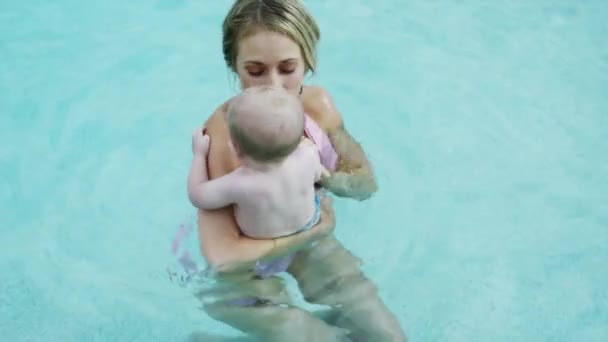 Madre jugando con el bebé hijo en la piscina — Vídeo de stock