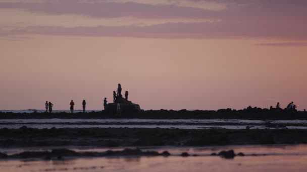 Gün batımında sahilde yürüyüş insanlar — Stok video