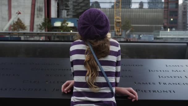 Chica apoyada en el borde del 11 de septiembre 2001 memorial — Vídeos de Stock