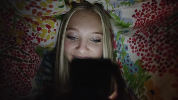 Dívka, pomocí telefonu na posteli v noci — Stock video