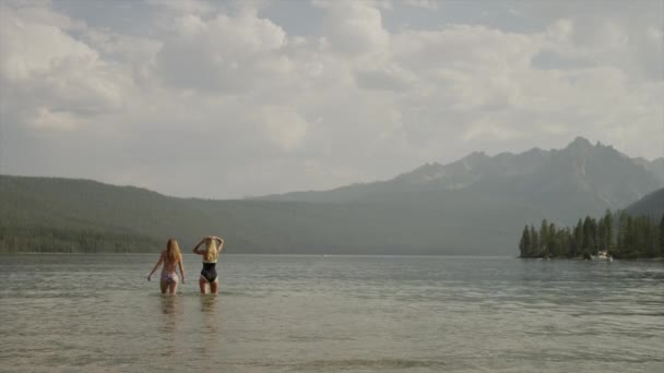 Jonge vrouwen waden in lake — Stockvideo