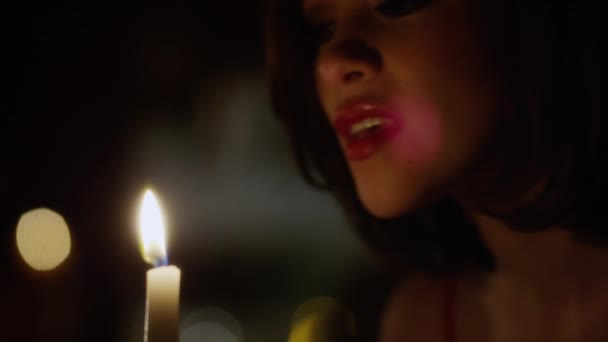 Жінка вибухає полум'я свічки — стокове відео