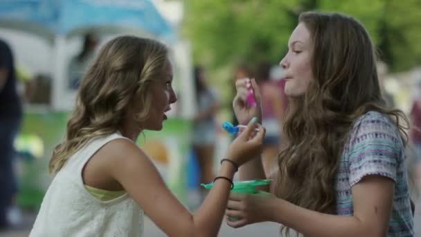 Meninas comendo gelo raspado na feira — Vídeo de Stock