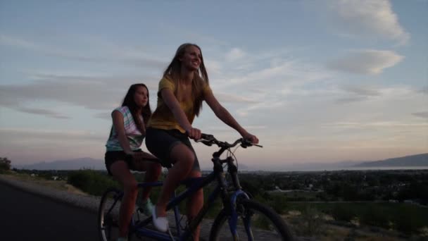 Frauen fahren Tandemfahrrad auf der Straße — Stockvideo