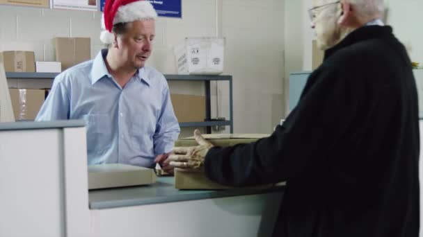 Ouderen man mailing perceel op postkantoor — Stockvideo