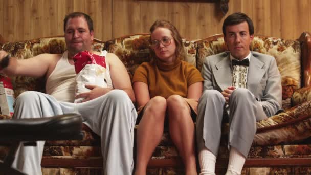 Man in pajamas sitting by couple on sofa — Stock Video