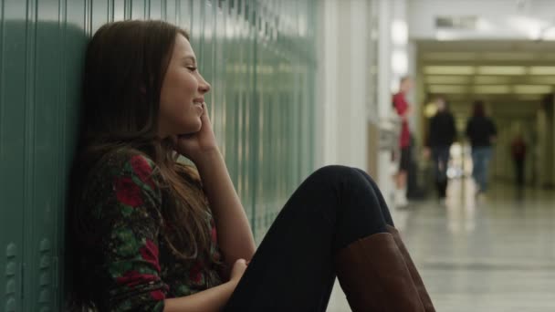 Chica sentada en la escuela y hablando por teléfono — Vídeos de Stock