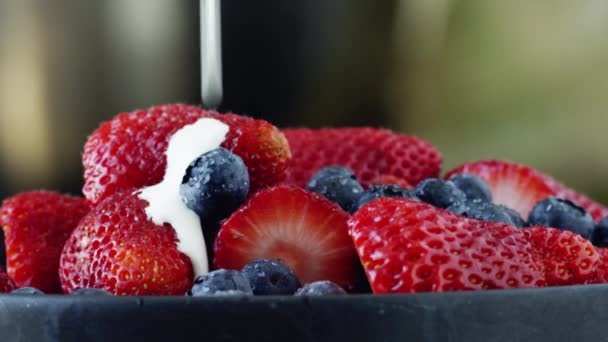 Grädde som hälls på blåbär och jordgubbar — Stockvideo