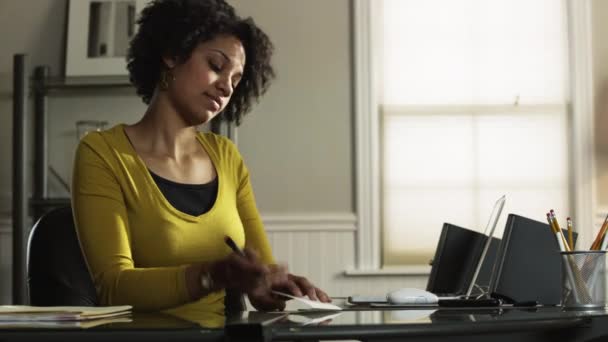 Jonge vrouw schrijven kaart in office — Stockvideo